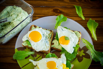fried toast with cheese spread of arugula and fried egg in a plate