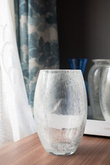 Mid-century modern glass vases in blue and green interior, before the window