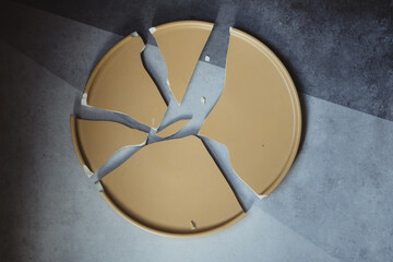 One broken empty yellow ceramic dish.