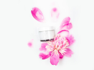 Obraz na płótnie Canvas Cream and peony flower in a bath with milk. Gentle care. Conceptual photo: the best cosmetic tool for body and face care. Natural cosmetics, mock up.