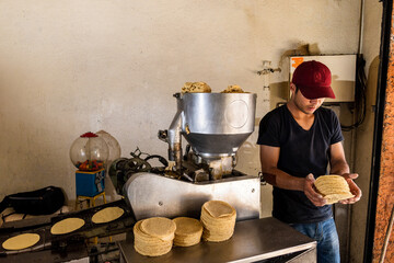 young man selling tortillas of nixtamal