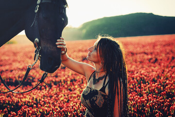 Portrait of woman and horse outdoors. Woman stroking a horse.