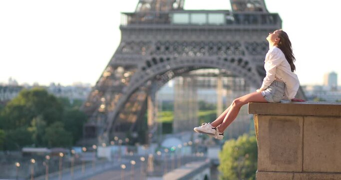 Beautiful young girl in Paris near the Eiffel tower at morning