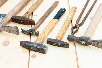 Set of vintage well used hand construction tools for handyman, hammers, on a wooden background .