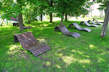 Wooden sun beds in the summer city Park