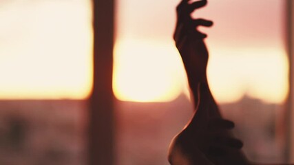 Spiritual sunset. Tranquility meditation. Female hands graceful gesturing over blur orange glow.