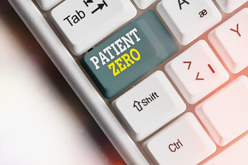 Conceptual hand writing showing Patient Zero. Concept meaning primary disease carrier of the highlycontagious disease White pc keyboard with note paper above white key copy space