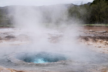 Strokkur geyser in Iceland a fraction of a second before the eruption with boiling hot water