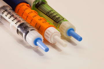 Diabetic insulin syringe injectors, injector pen. Three syringe-pen for diabetic patient on white...