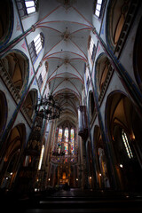 Scenic interior of the famous Catholic Church (De Krijtberg Kerk). Frescos, glass paintings and details of the vibrant ceiling decors, sanctuary, are visible.