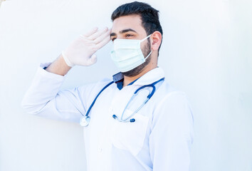 Arabic doctor doing military salute while wearing mask on his fa