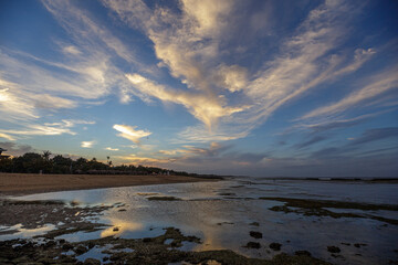 Landscape beautiful colorful golden sunset blue sky Bali, Indonesia. Serenity and calm concept. The sun sets behind the horizon on a cloudy day.