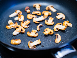 Champignon mushrooms frying in pan
