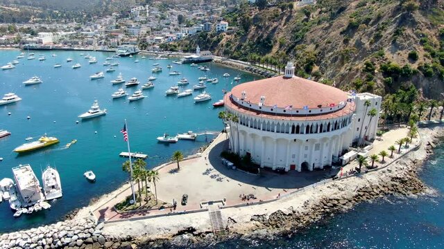 Aerial view of Catalina Casino and Avalon harbor with sailboats, fishing boats and yachts moored in calm bay, famous tourist attraction in Santa Catalina Island, Southern California