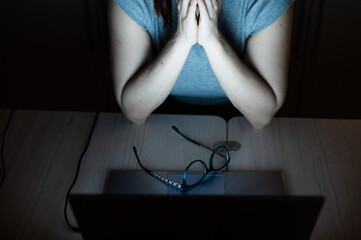 Tired, exhausted woman in frustration working overtime on a laptop. Faceless female freelancer in despair. Night work from home. Deadline