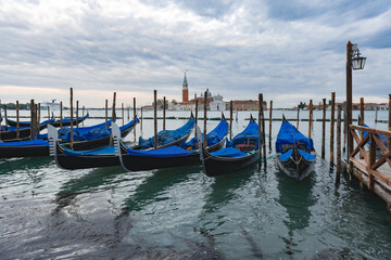 Fototapeta na wymiar Gondolas anchored by Piazza San Marco with San Giorgio di Maggiore church in Venice,