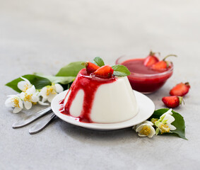 Cream berry dessert panna cotta vanilla with strawberry sauce on a light background