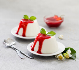 Italian dessert panna cotta vanilla with strawberry sauce on a light background