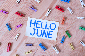 Handwriting text Hello June. Conceptual photo a new month to plan your activities for fun and adventures Colored clothespin papers empty reminder wooden floor background office