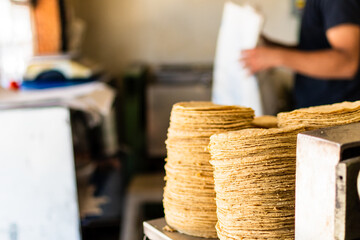 tortillas stacked on a tortilla machine