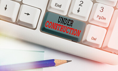 Writing note showing Under Construction. Business concept for building that is unfinished but...