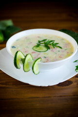summer cucumber soup with vegetables on a wooden table