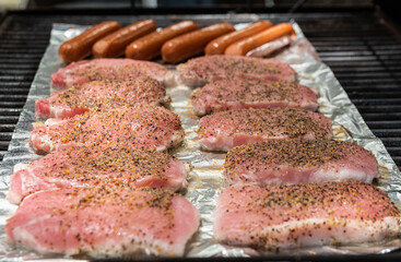 Seasoned pork loin and hot dogs on grill