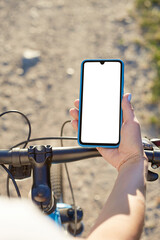 Girl holds a mobile phone riding on the bicycle. Mockup
