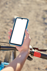 Girl holds a mobile phone riding on the bicycle. Mockup
