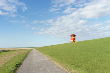 Bunt angemalter Leuchtturm bei Pilsum an der deutschen Nordseeküste	