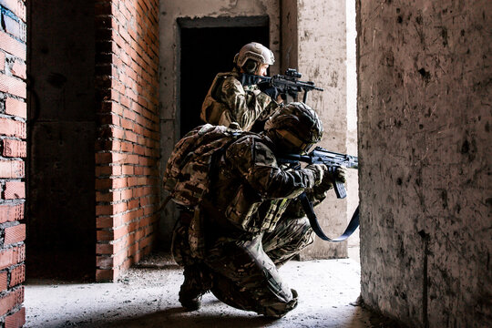 Two Us Army Soldiers Patrolling The Streets Sitting In A Building With Rifles