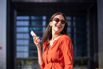 Fototapeta premium Young smiling pretty woman reading messages on the mobile phone