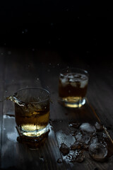 Glass of whiskey with ice and spray. Beautiful food photo.
