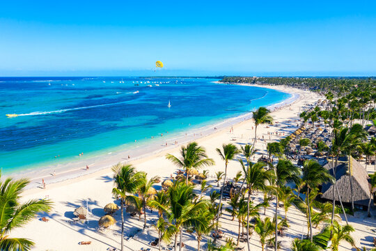 Aerial view of Bavaro beach Punta Cana tropical resort in Dominican Republic. Beautiful atlantic tropical beach with palms, umbrellas and parasailing balloon