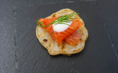Salted salmon with dill on a pancake.