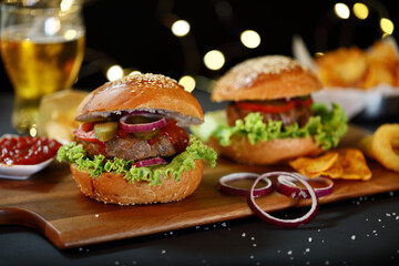 Big hamburger with salad, french fries, onion rings and cheese.