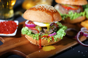Big hamburger with salad, french fries, onion rings and egg.
