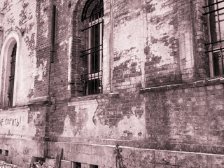 Fototapeta premium Wall of ancient curch , brick building with windows and metall bars.