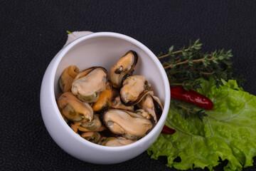 Pickled mussels in the bowl served pepper, garlic and salad