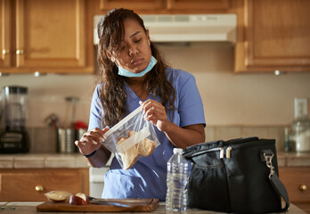 filipina nurse in home kitchen packing lunch for work