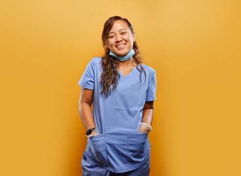 portrait of happy filipina nurse on orange background