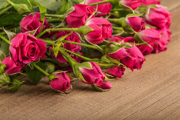 Beautiful Roses Bouquet. Pink flowers on wooden Background. Place for text, flat lay, top view, copy space