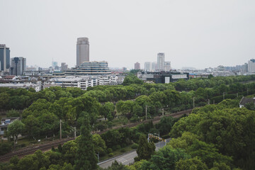 Railway between trees and city skyline viewed from South Lake scenic area in Jiaxing, China