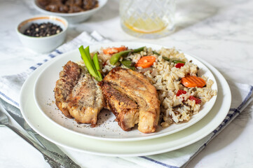 Baked pieces of pork with brown rice and vegetables