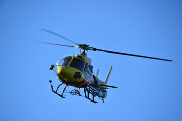 Close up of a helicopter in action against a blue sky