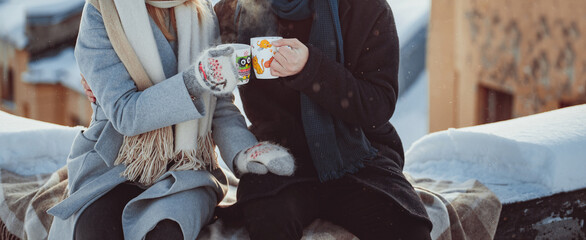 Men and women hands holding cups of hot tea on winter date