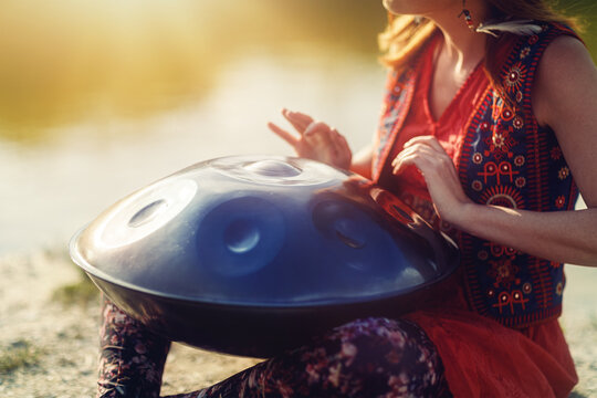 beautiful woman playing with hangdrum in nature.