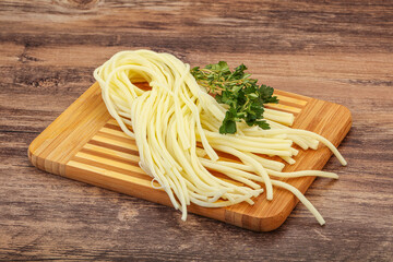 Chechil spaghetti cheese over board