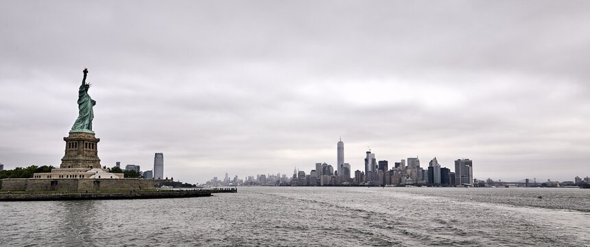 Panoramic shot of the amazing Statue of Liberty on New York city background - Powered by Adobe