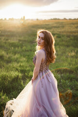 Fototapeta na wymiar beautiful young woman in long purple dress standing posing against the backdrop of a fairytale castle
